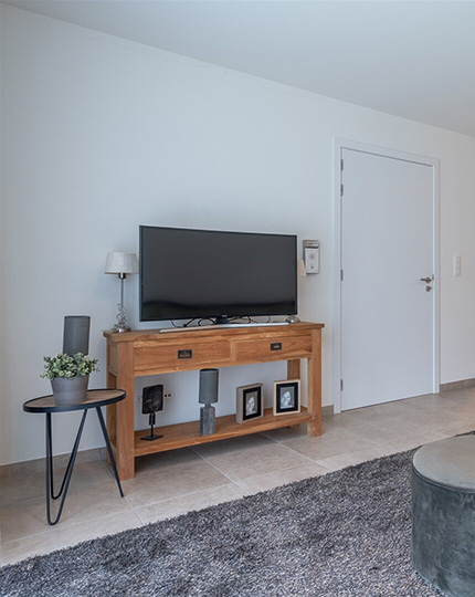 TV meubel met televisie in de leefruimte in een assistentie woning van Gaudium in Mol
